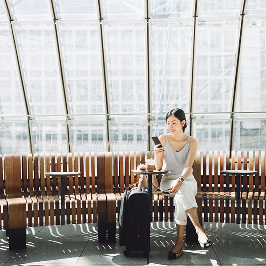 Woman sat in airport with luggage. Credit: Getty Images